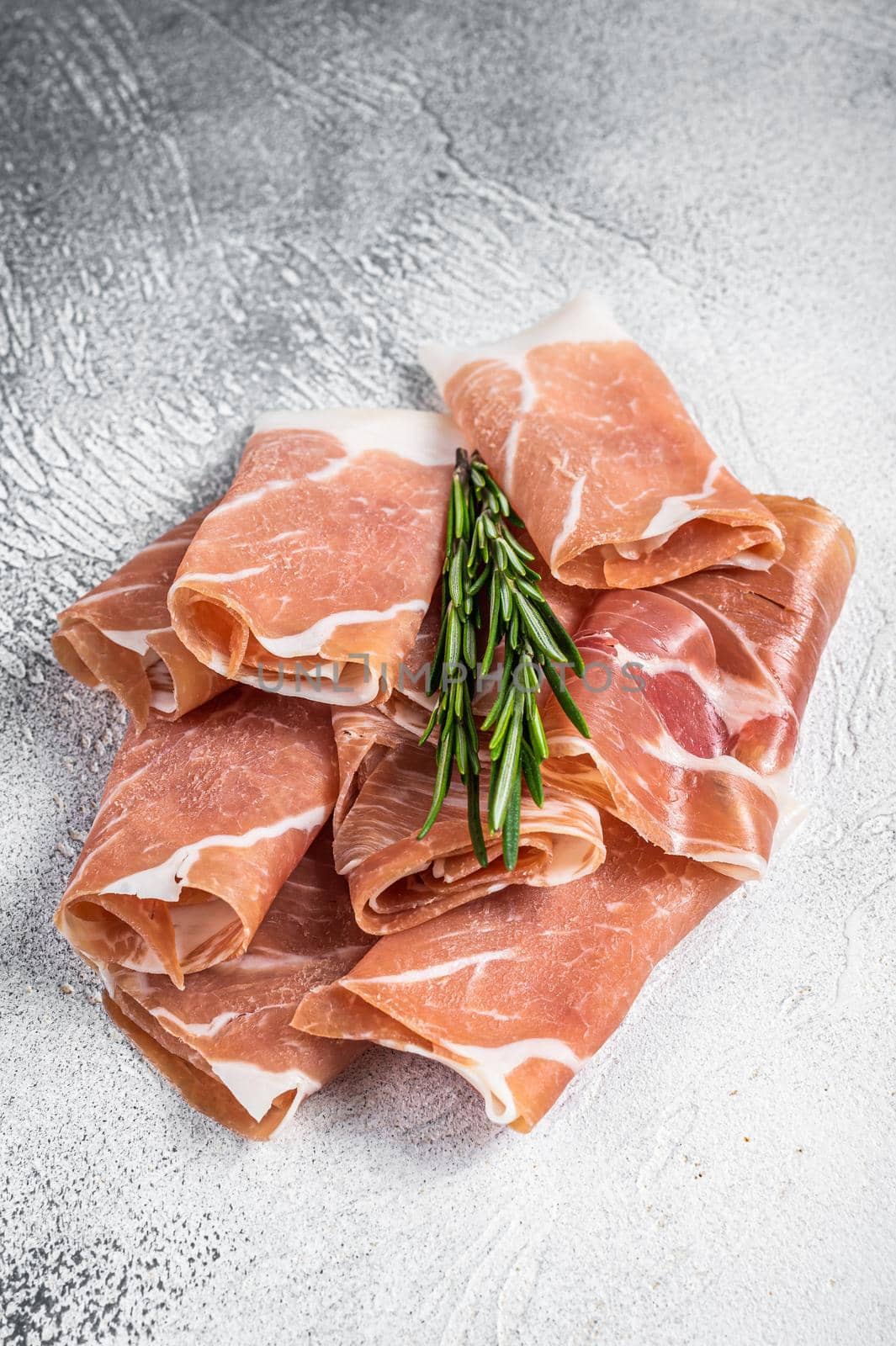 Italian prosciutto crudo parma ham on a table. White background. Top View by Composter