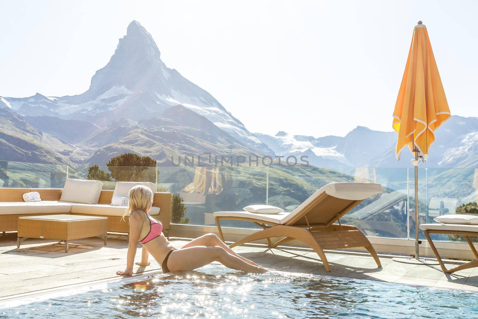 Woman enjoying the panoramic view from the pool in the alps