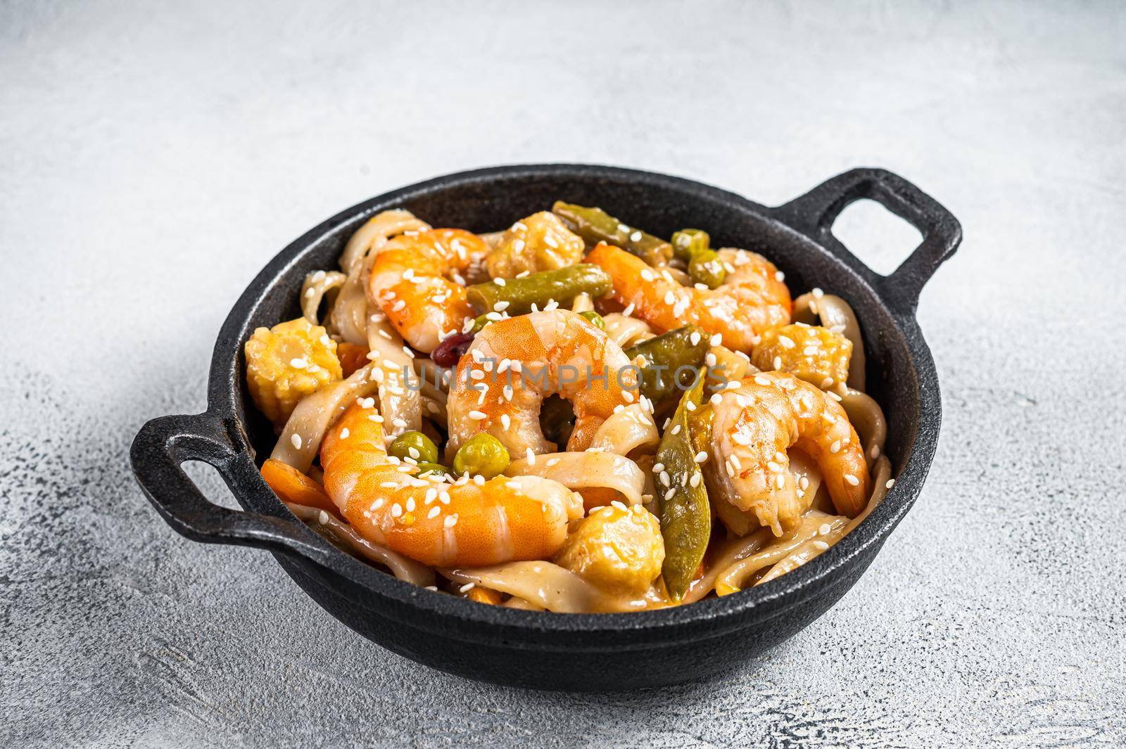 Udon stir-fry noodles with shrimps prawns in a pan. White background. Top view by Composter