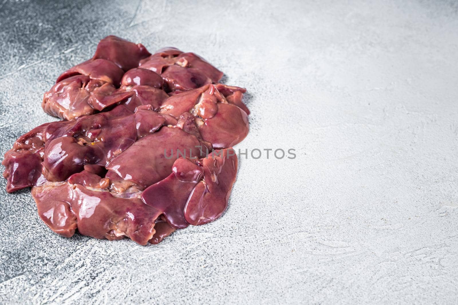 Raw chicken liver meat on butcher table. White background. Top view. Copy space.