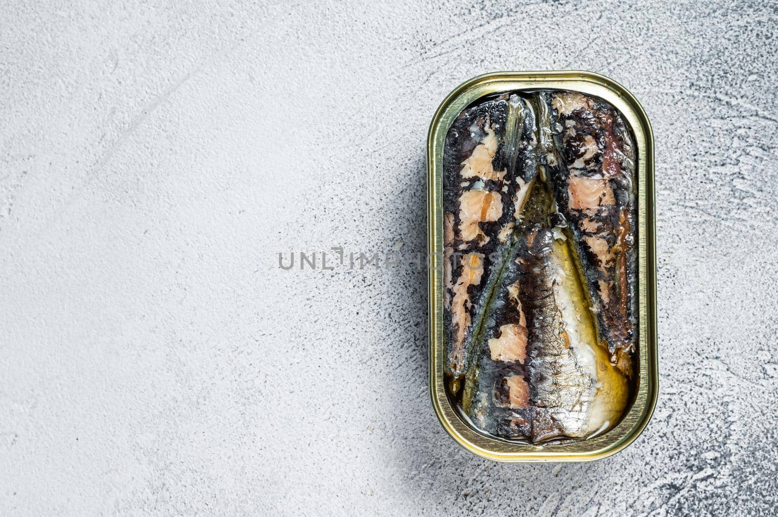 Open can with sardine in olive oil. White background. Top view. Copy space by Composter