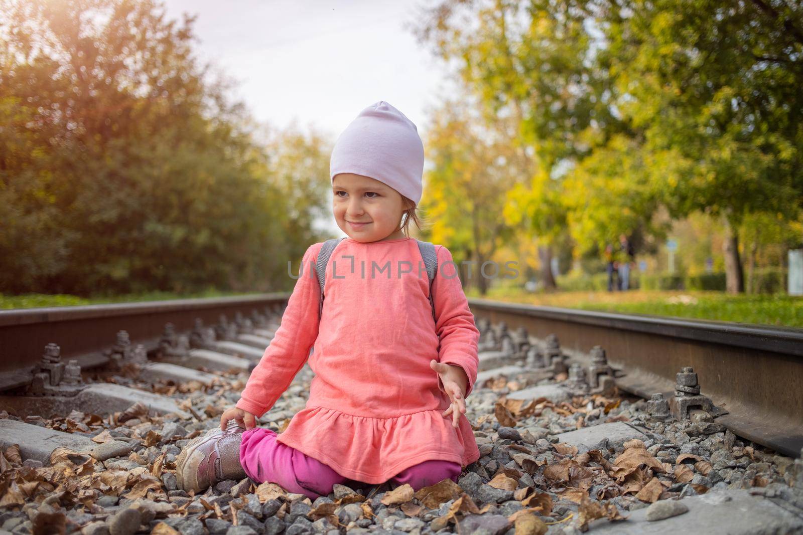 little girl sitting on the railroad tracks by Mariaprovector