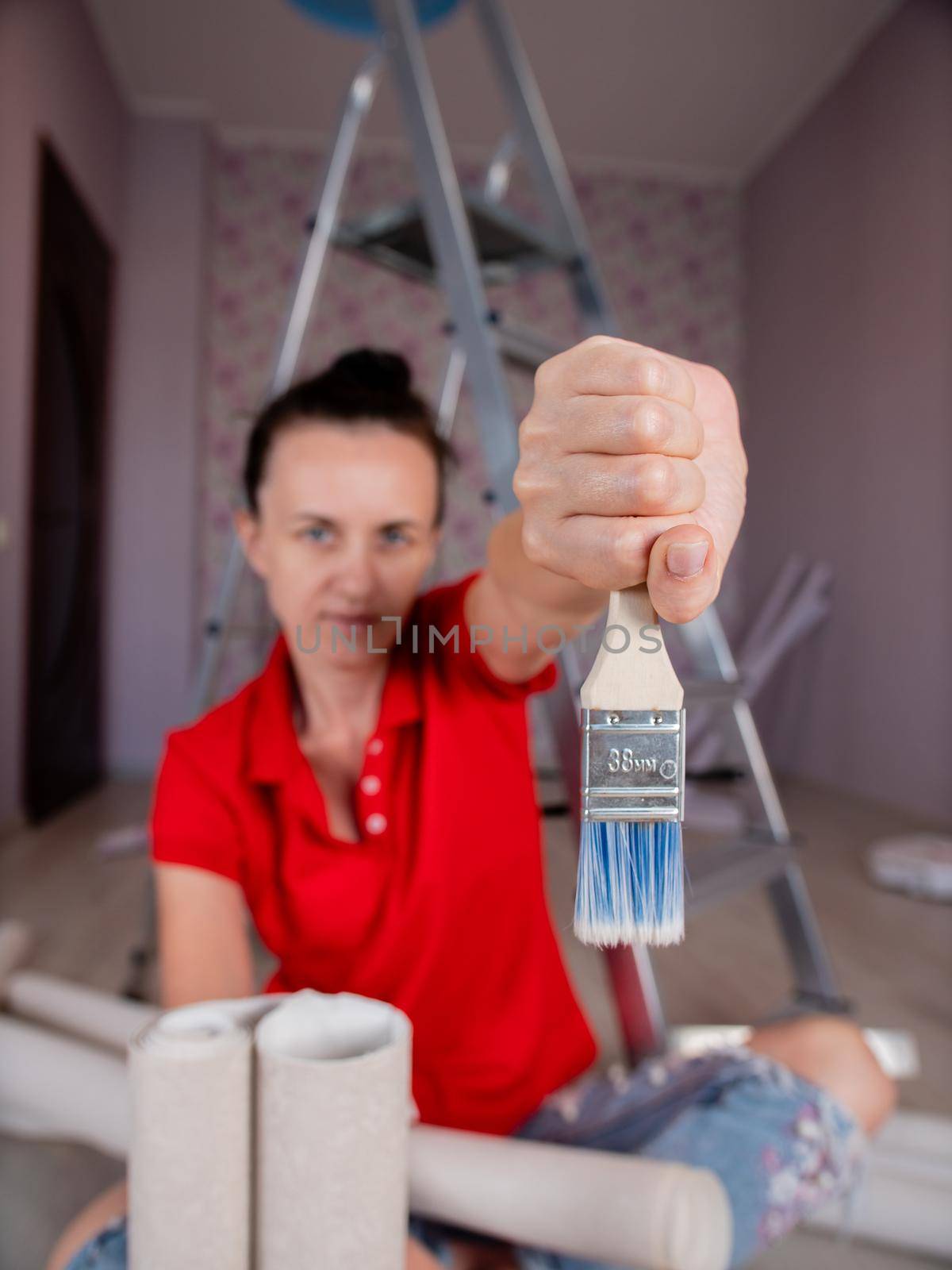 A woman holds a construction paint brush in her hands. by Utlanov