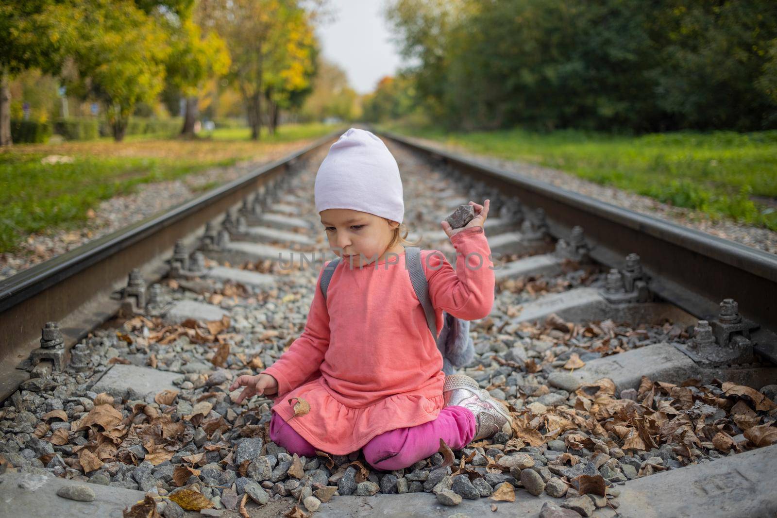 little girl sitting on the railroad tracks by Mariaprovector