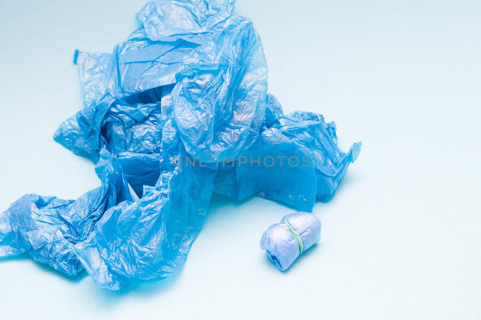 a lot of blue shoe covers on a blue background, copy space, a small bundle of shoe covers tied with an elastic band