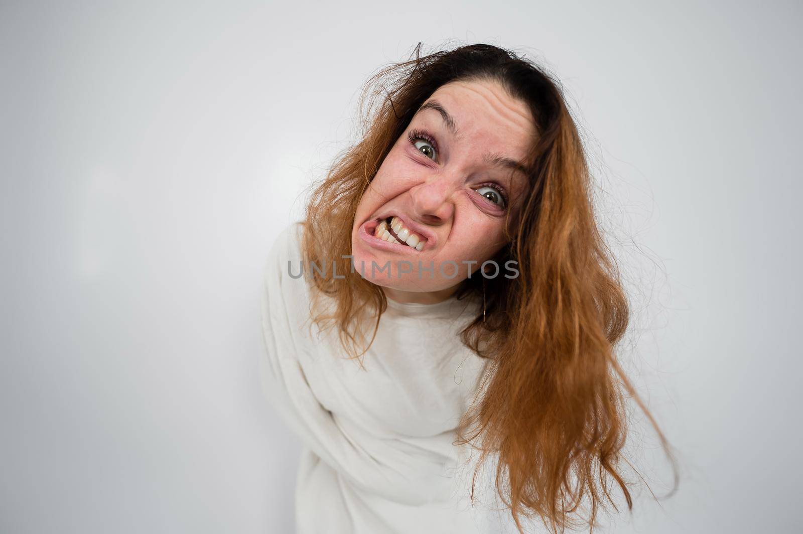 Close-up portrait of insane woman in straitjacket on white background. by mrwed54