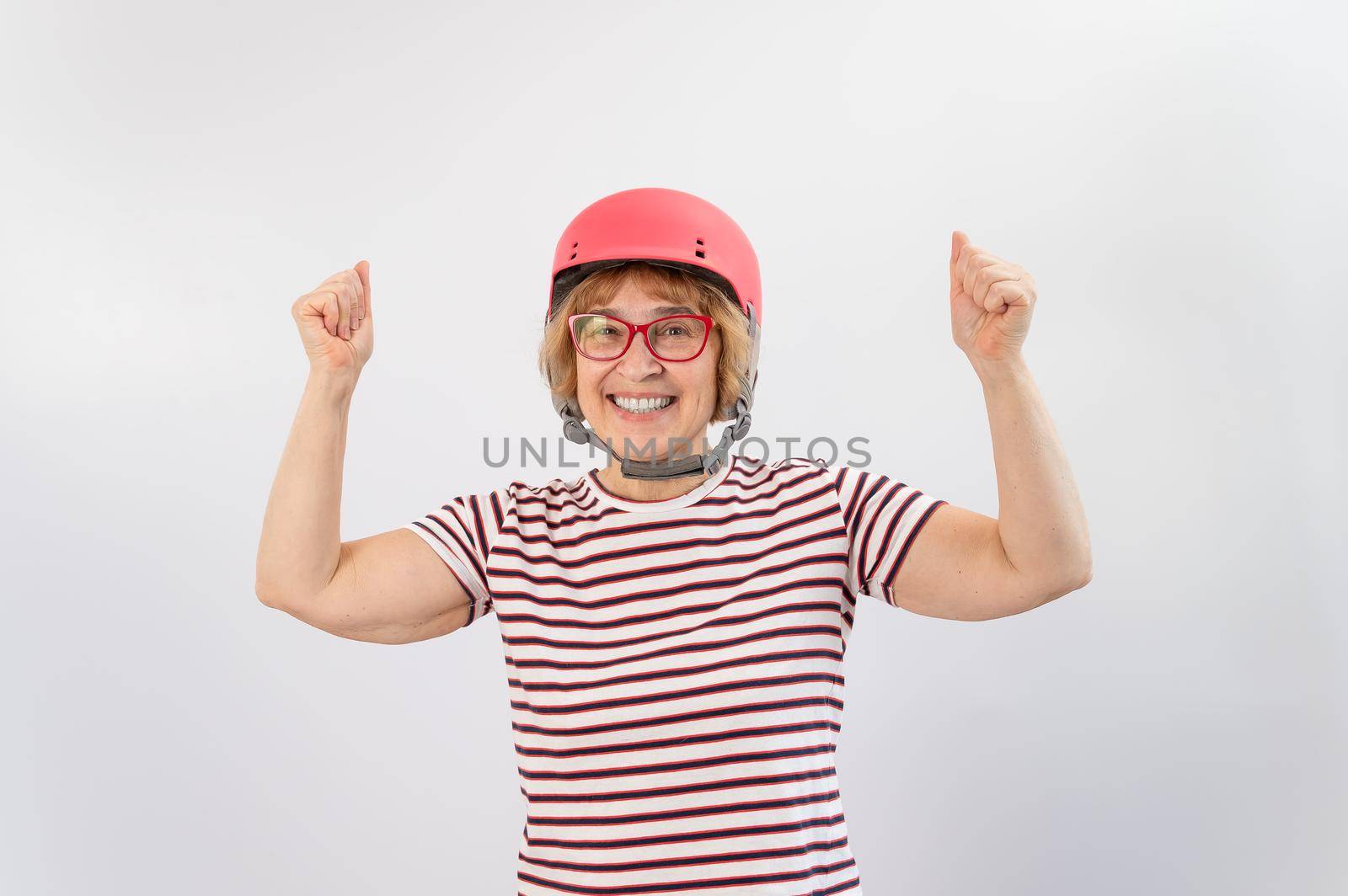 Elderly woman in ski helmet showing thumb up on white background. by mrwed54