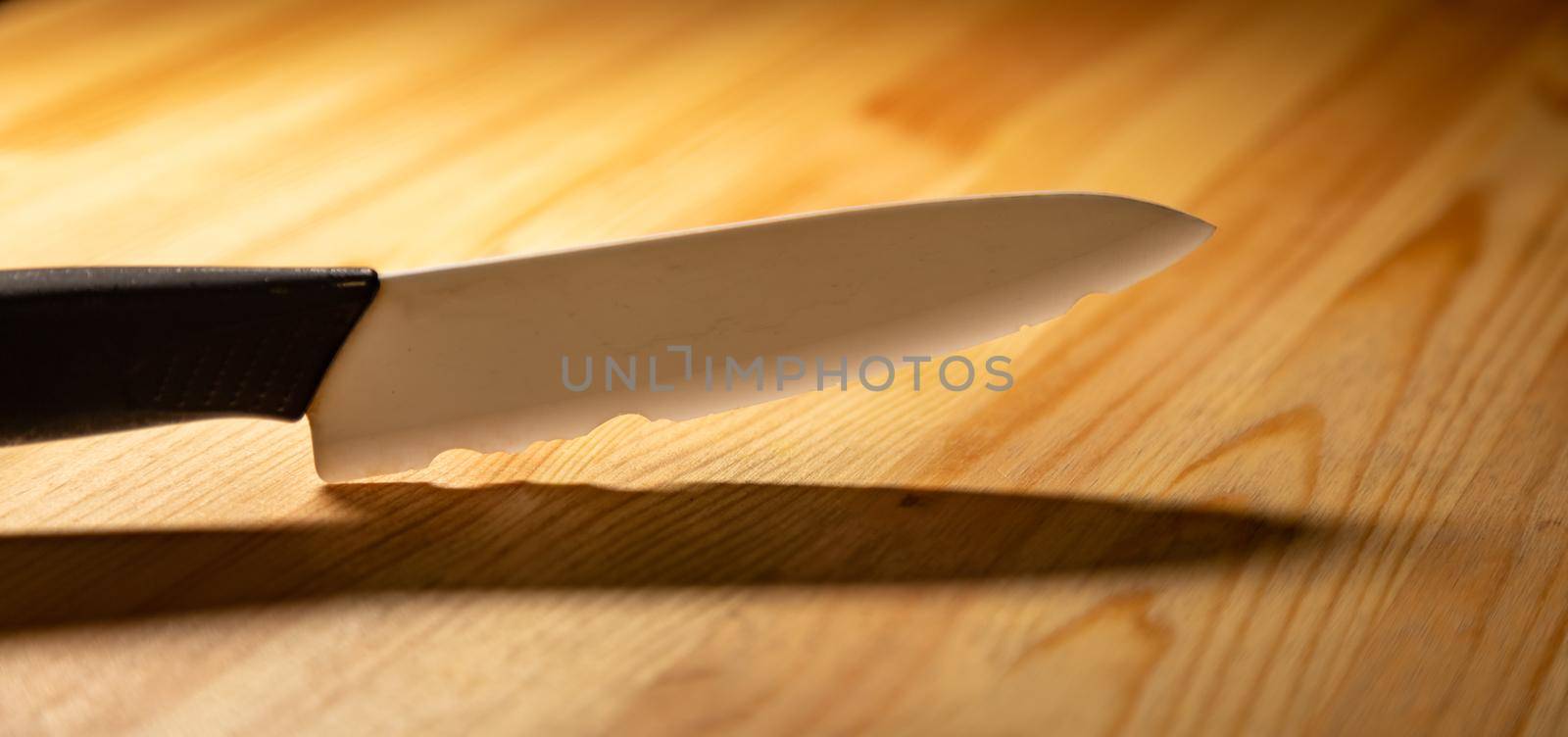 close up old white ceramic knife with a chipped blade. broken substandard knife