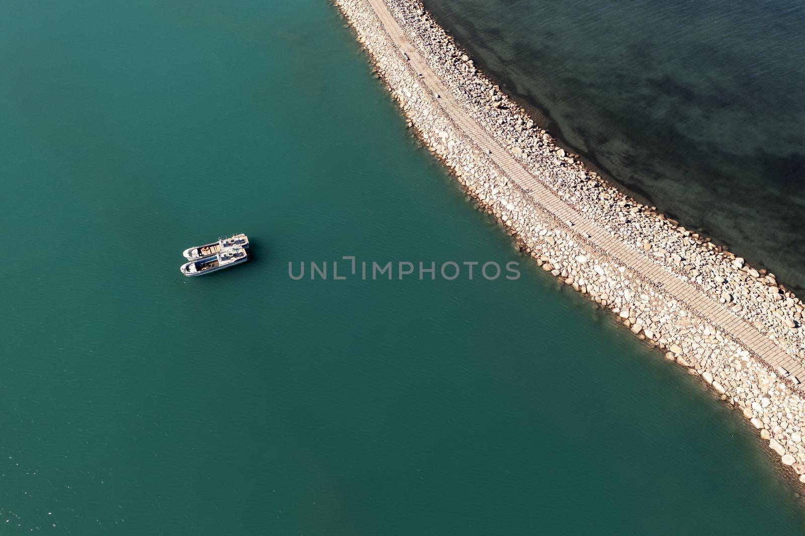Road and boats on the lake. Shot in Sayram Lake in Xinjiang, China. by vinkfan