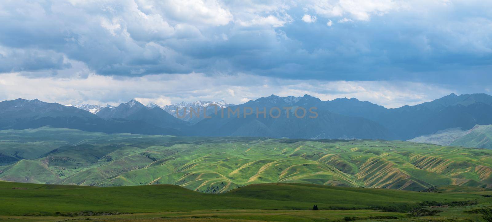 Grassland and mountains in a cloudy day. Photo in Kalajun grassland in Xinjiang, China. by vinkfan