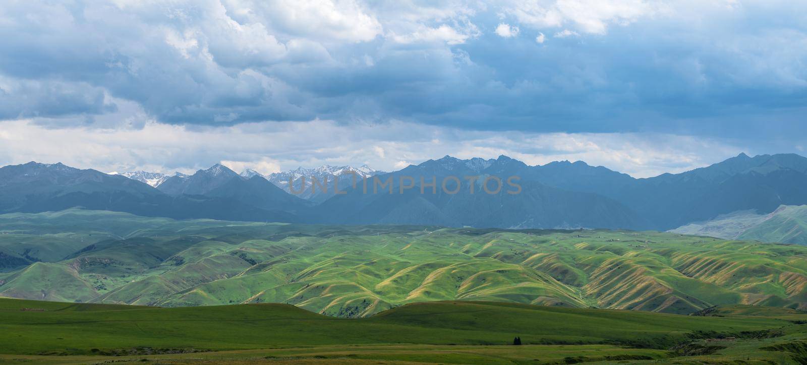 Grassland and mountains in a cloudy day. Shot in Xinjiang, China.