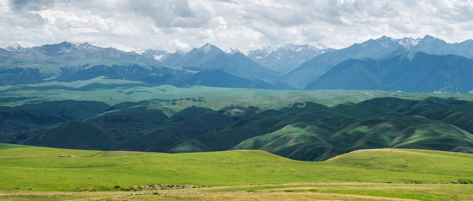 Grassland and mountains in a cloudy day. Shot in Xinjiang, China.