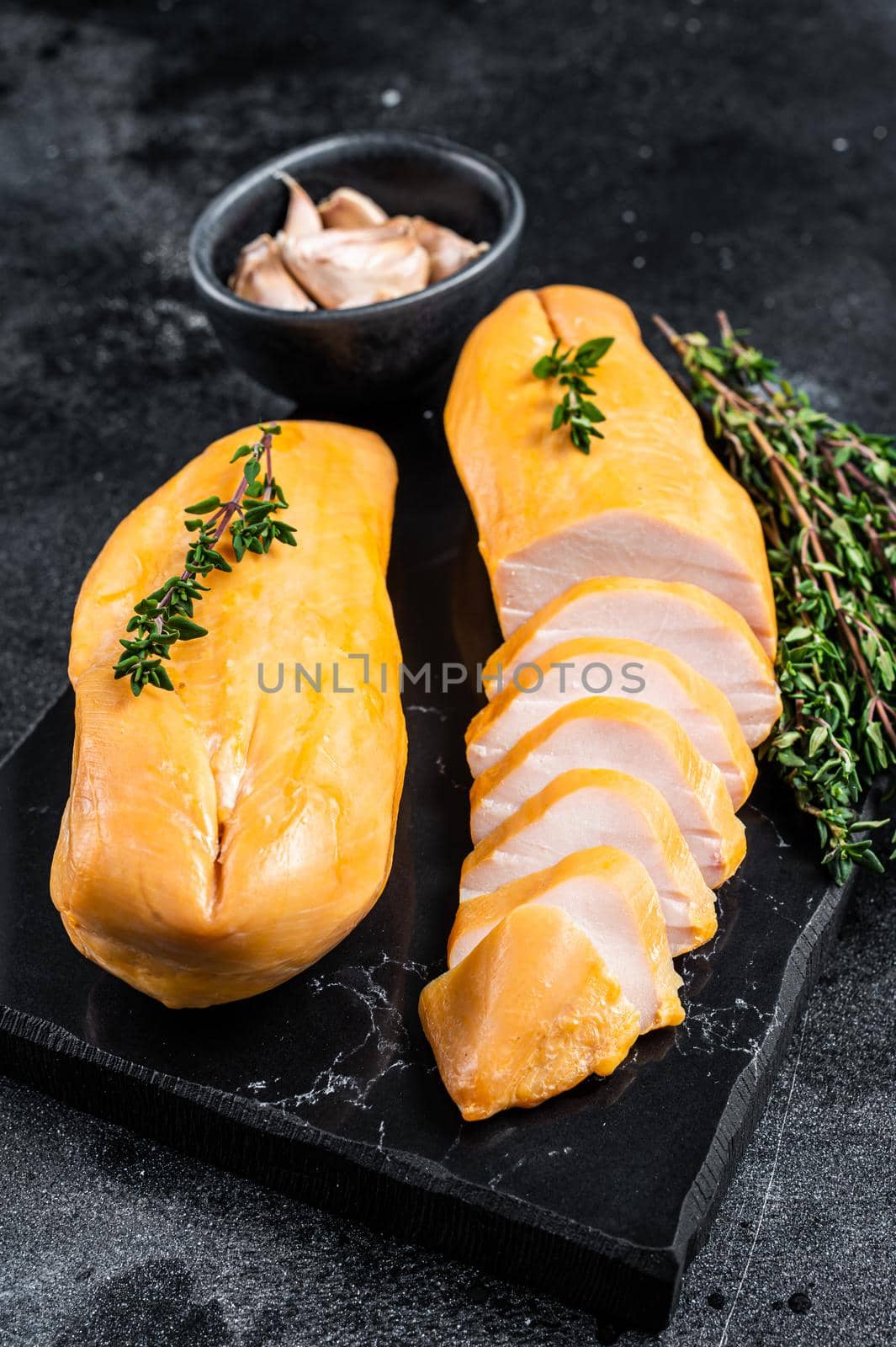 Smoked cut chicken breast fillet meat delicacy. Black background. Top view.