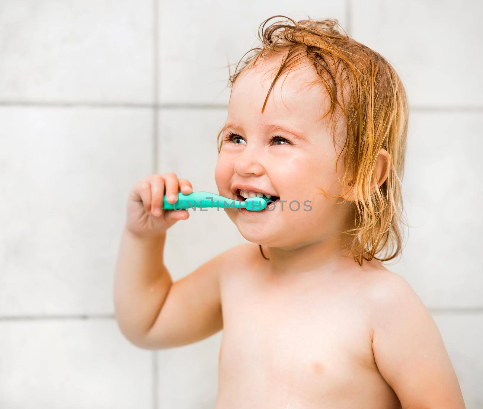 Dental hygiene. Cute baby brushing teeth in bathroom