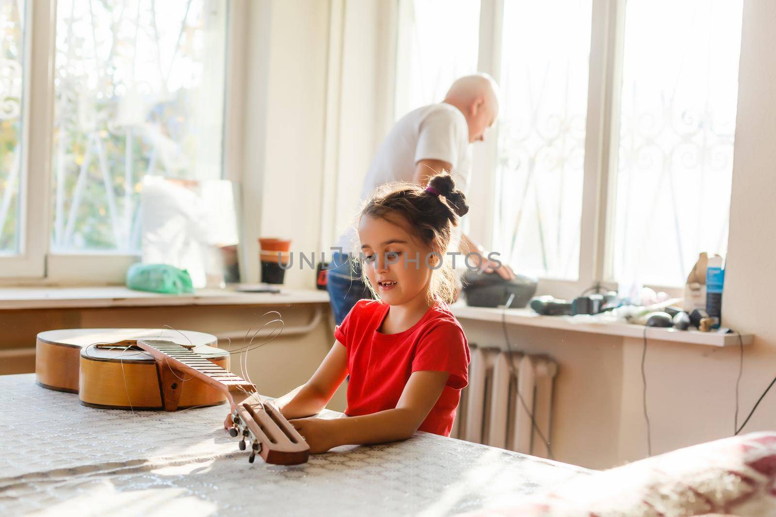 little girl holding a broken guitar, guitar repair