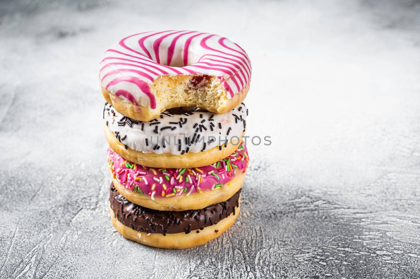 Stack of artisan donuts. White background. Top view. Copy space by Composter
