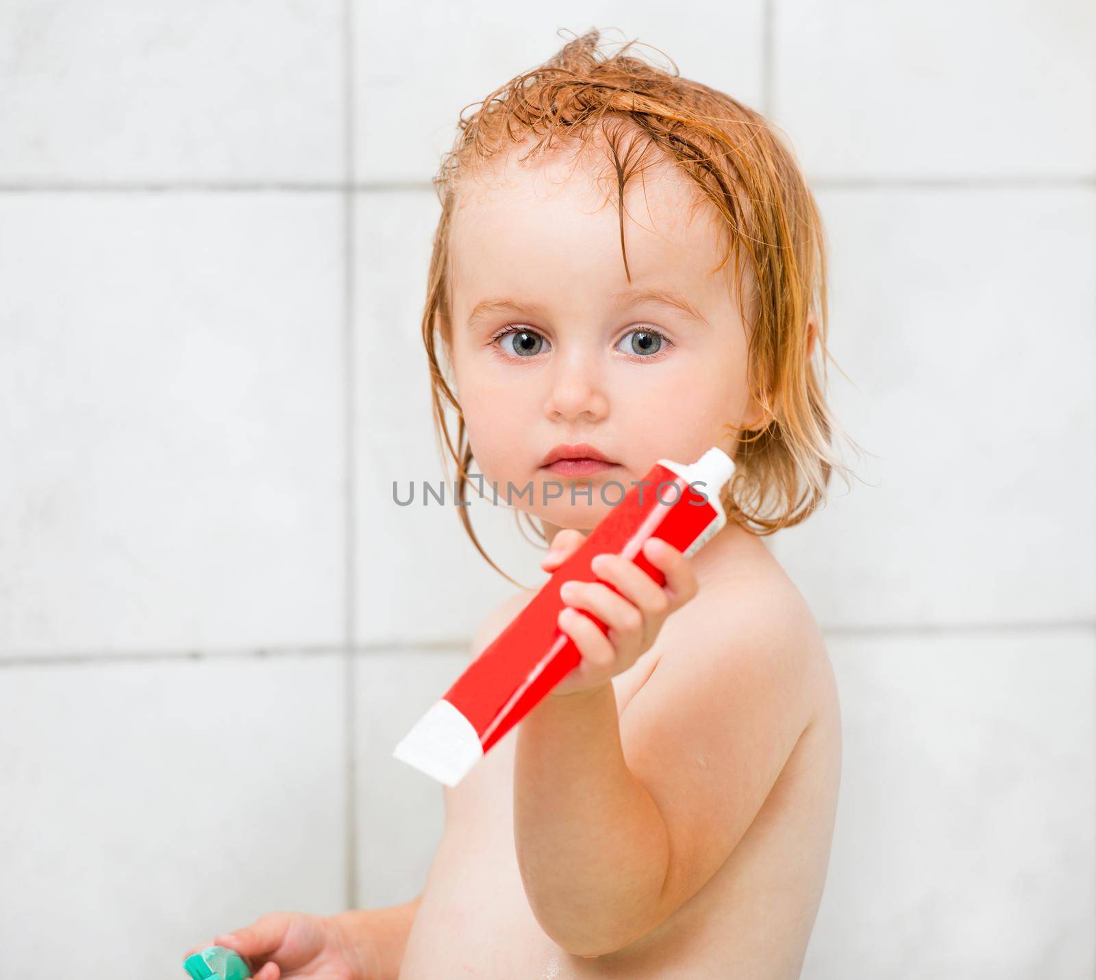 Dental hygiene. Beautiful baby with toothpaste in bathroom