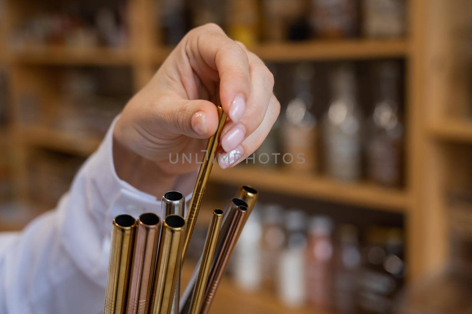 A woman holds a jar of reusable steel tubes. Eco concept.