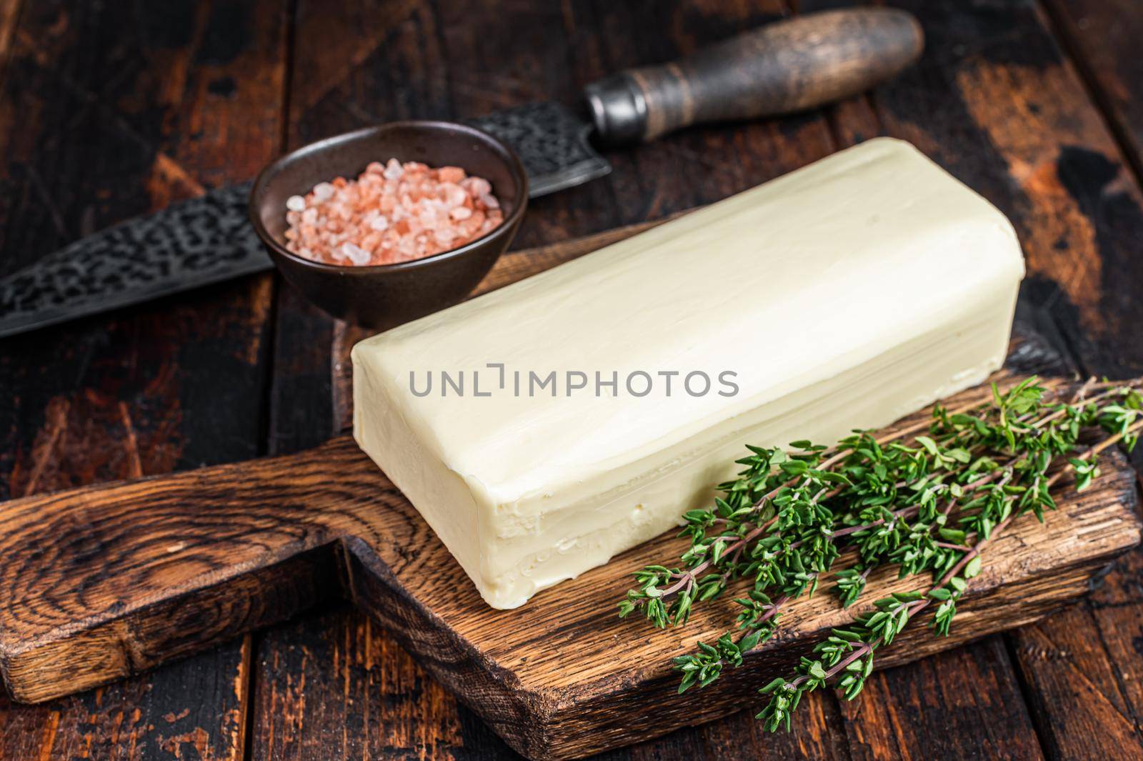Butter Spread block on a wooden board. Dark wooden background. Top view by Composter