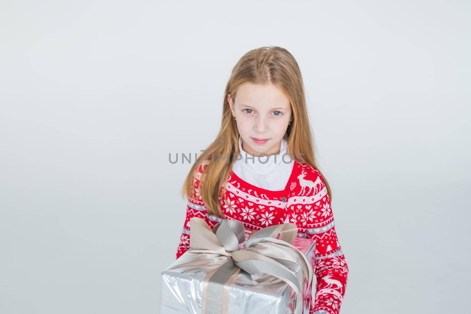 nice girl with Christmas present.Cute kid,child wears red knitted Nordic sweater holding gift, box celebrating. happy 2021 New Year. Merry Christmas presents shopping sale.holidays and people concept by YuliaYaspe1979