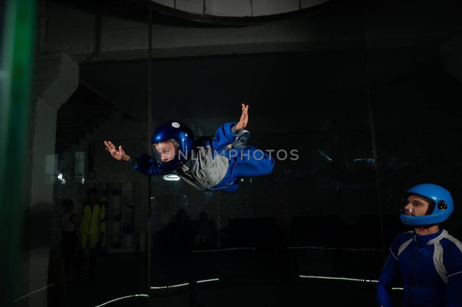 A man teaches a boy to fly in a wind tunnel