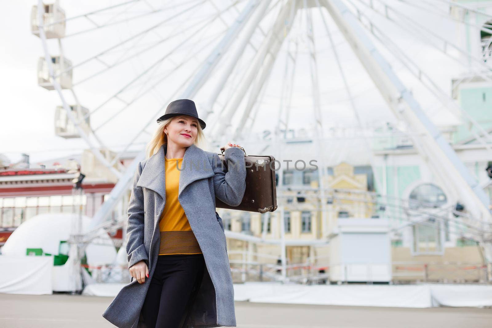 Stylish woman posing near ferris wheel