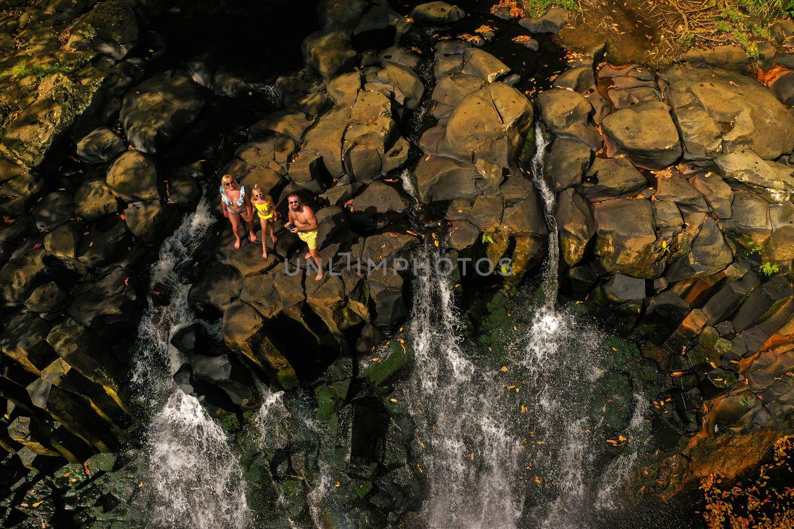 Family on the background of the Rochester waterfall on the island of Mauritius from a height.Waterfall in the jungle of the tropical island of Mauritius by Lobachad