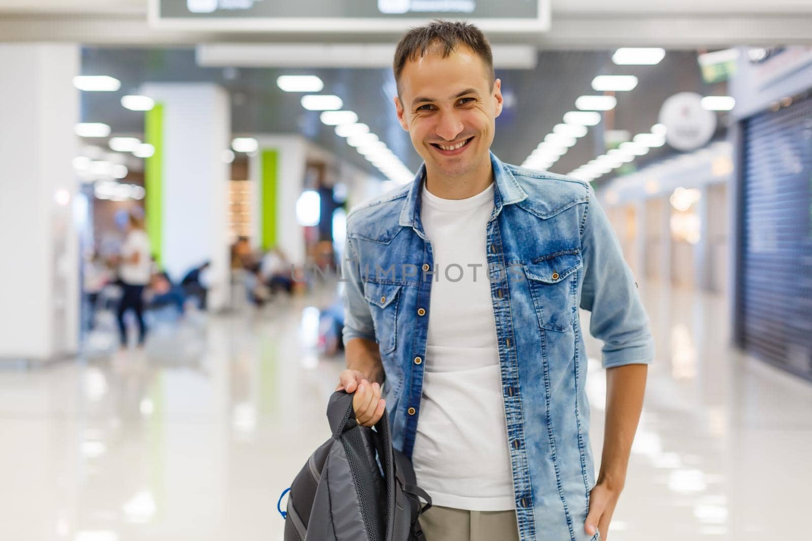Young man with backpack in airport in terminal by Andelov13