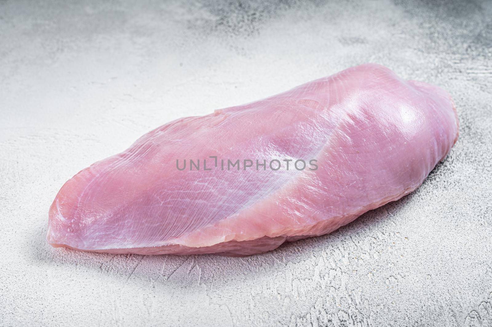 Raw whole big turkey breast fillet. White background. Top View.