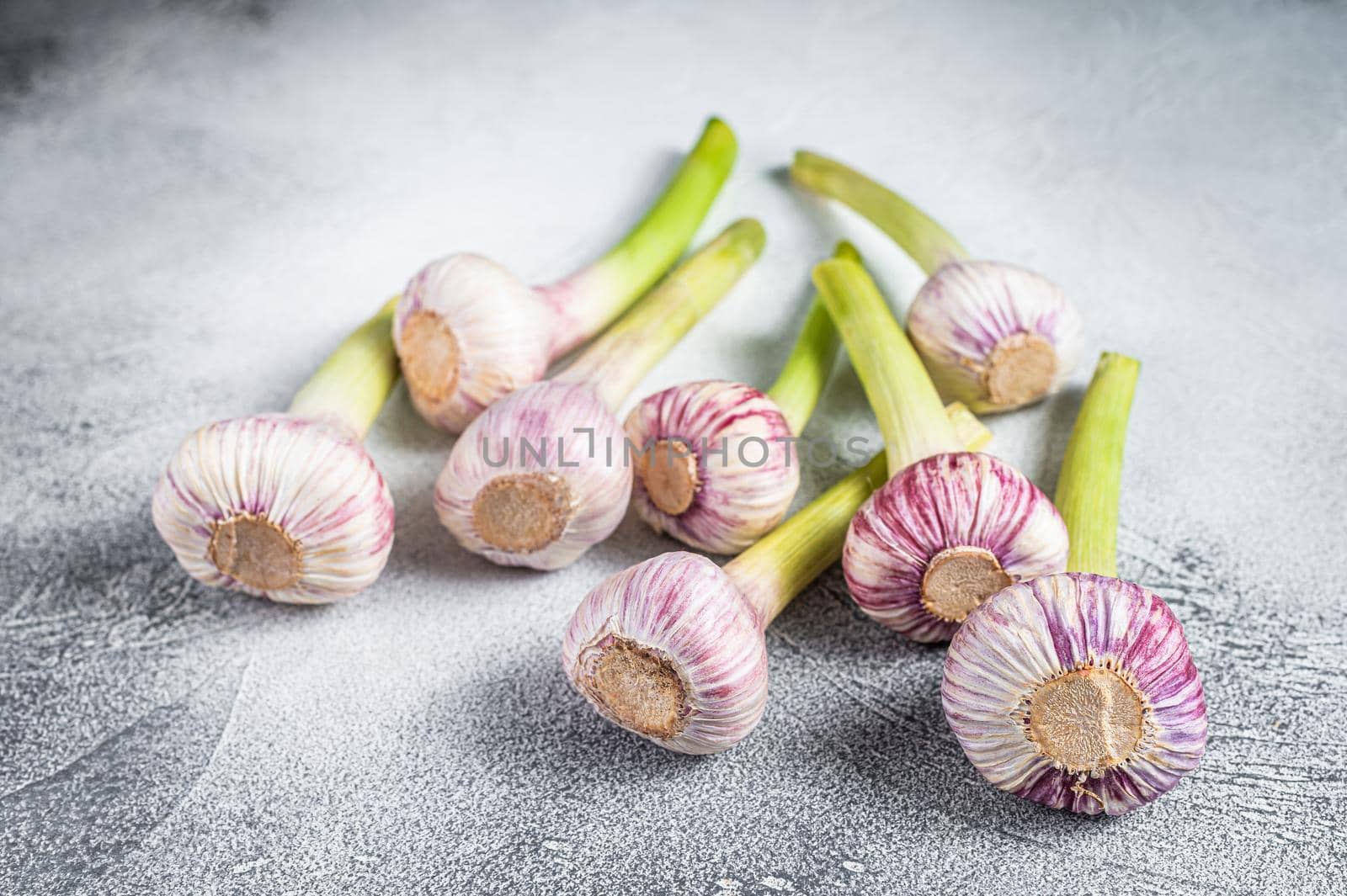Fresh Spring young garlic bulbs on kitchen table. White background. Top view.
