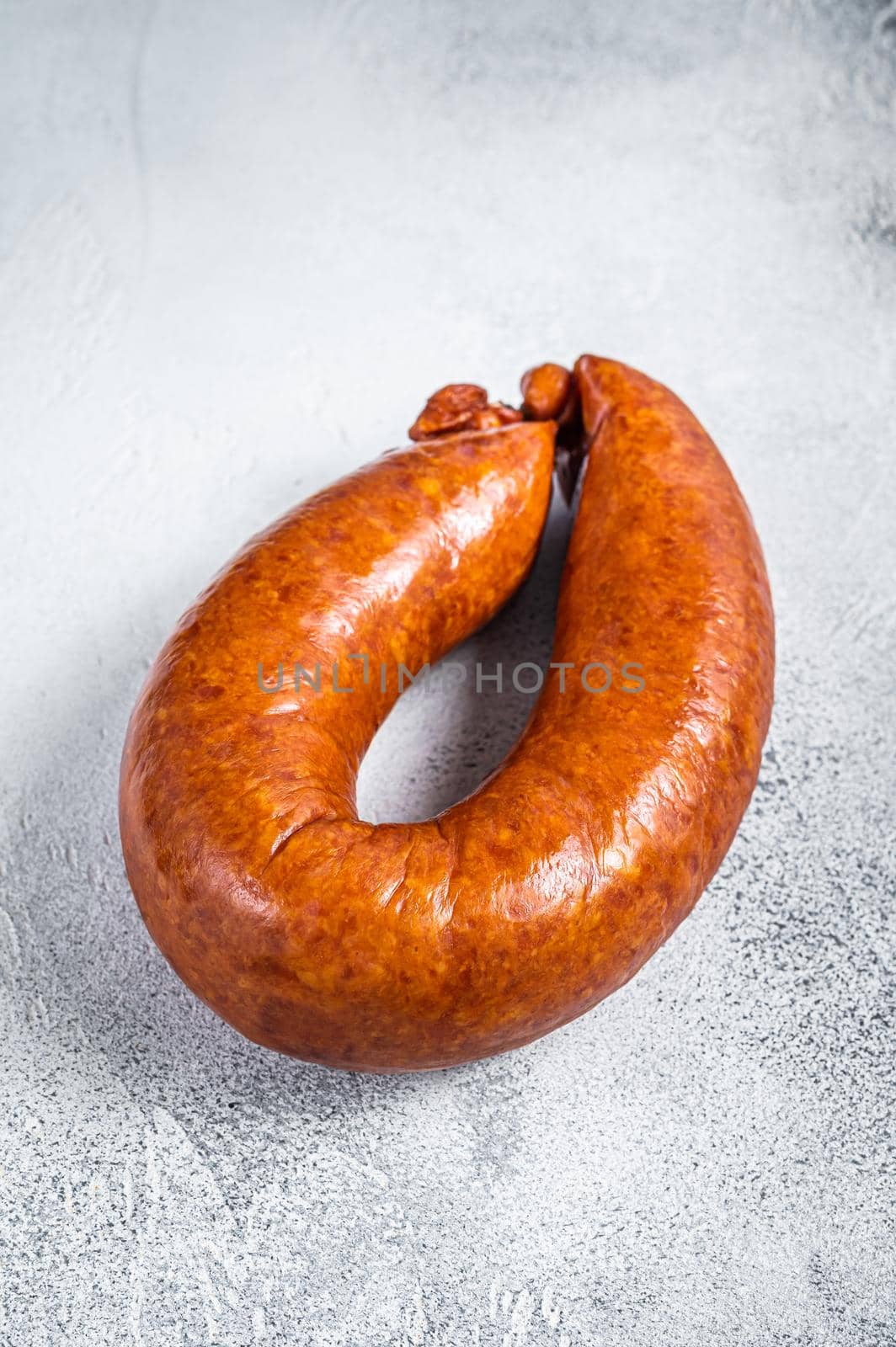 Smoked sausage on a white rustic table. White background. Top view.