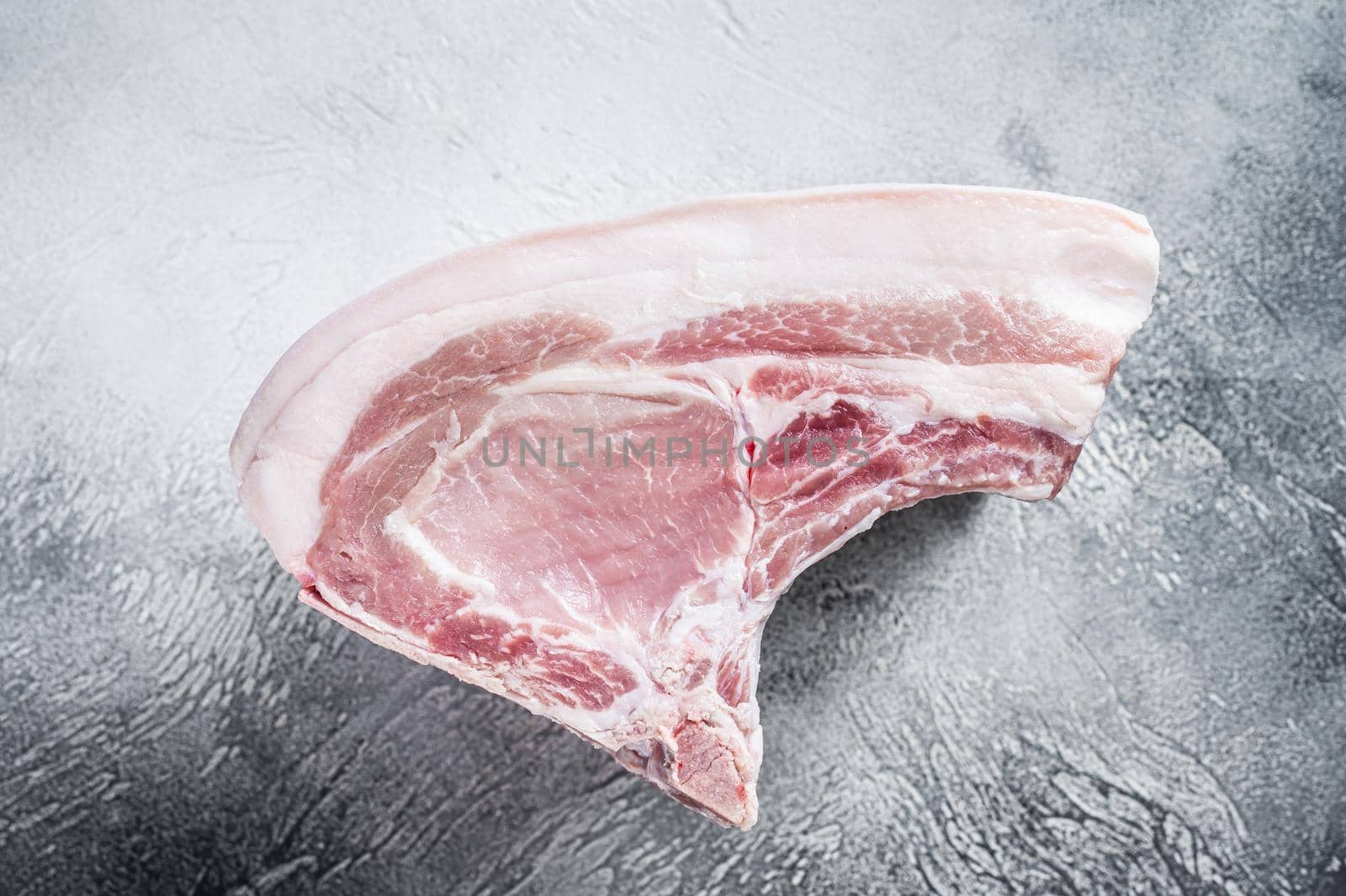 Raw whole rack of pork loin with ribs on kitchen table. White background. Top view by Composter