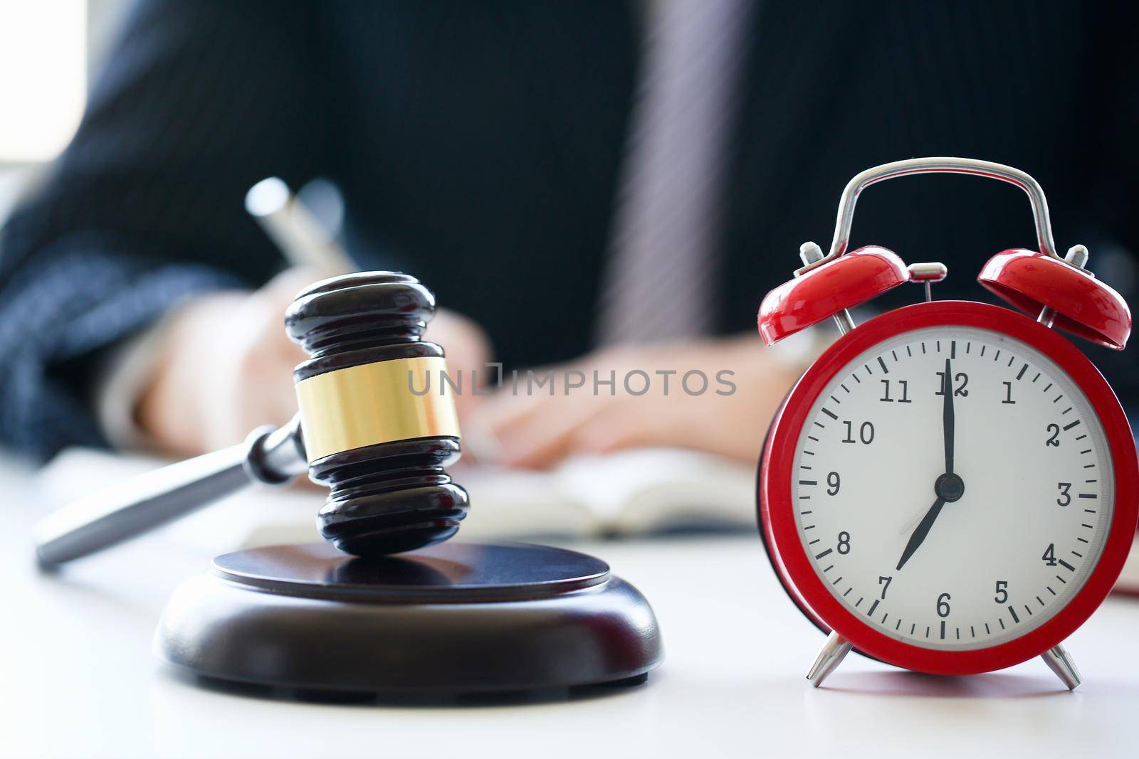 Red alarm slock and judge hammer lies on table in debate room for fair judgments economic notions of violations legal system fraud and punishment