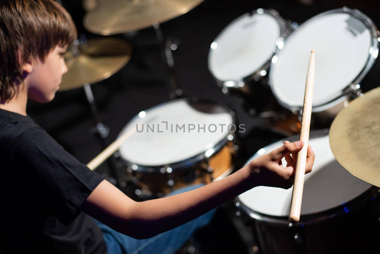 A boy plays drums in a recording studio by mrwed54