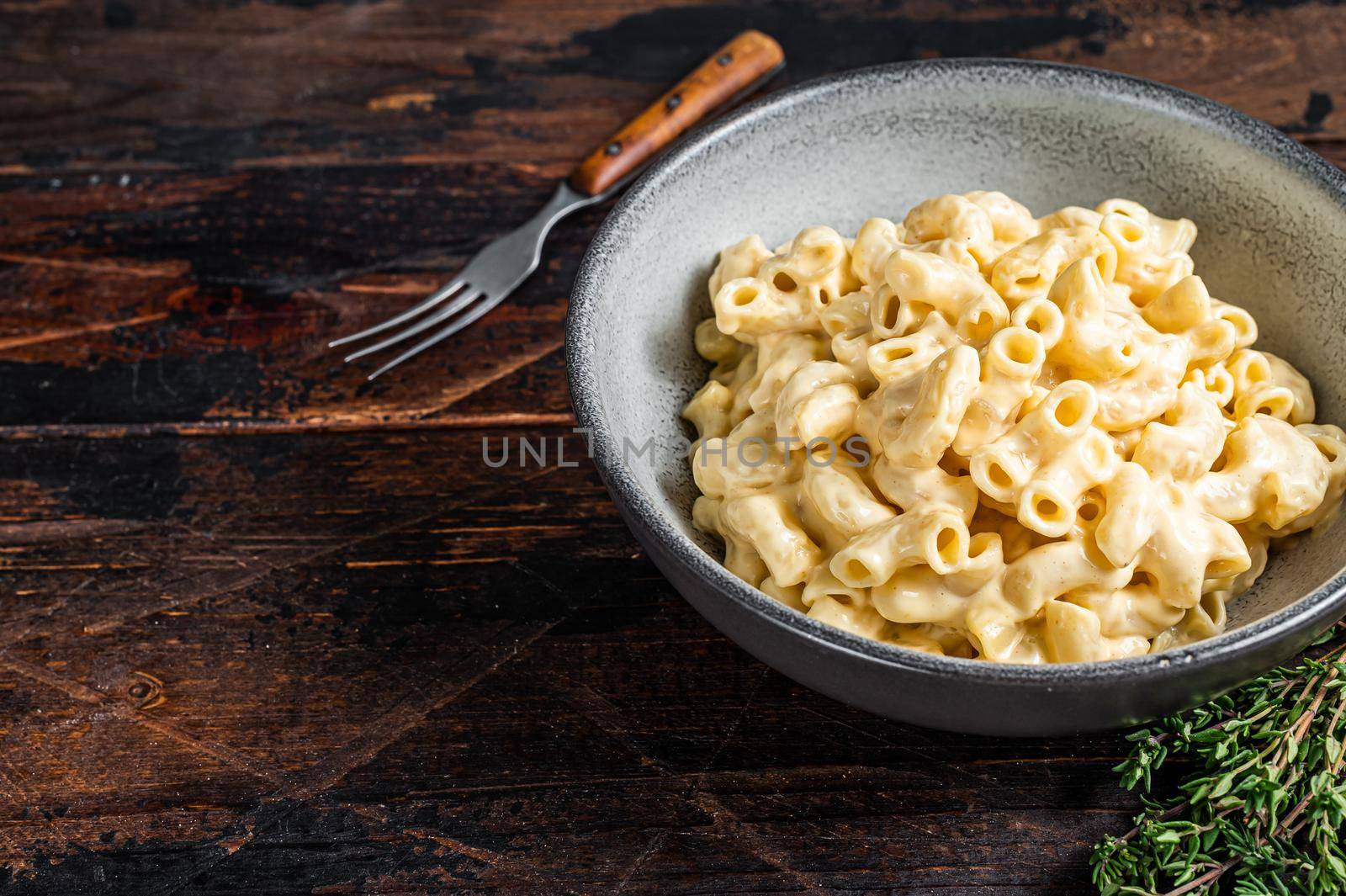 American dish Mac and cheese macaroni pasta with Cheddar. Dark wooden background. Top view. Copy space by Composter