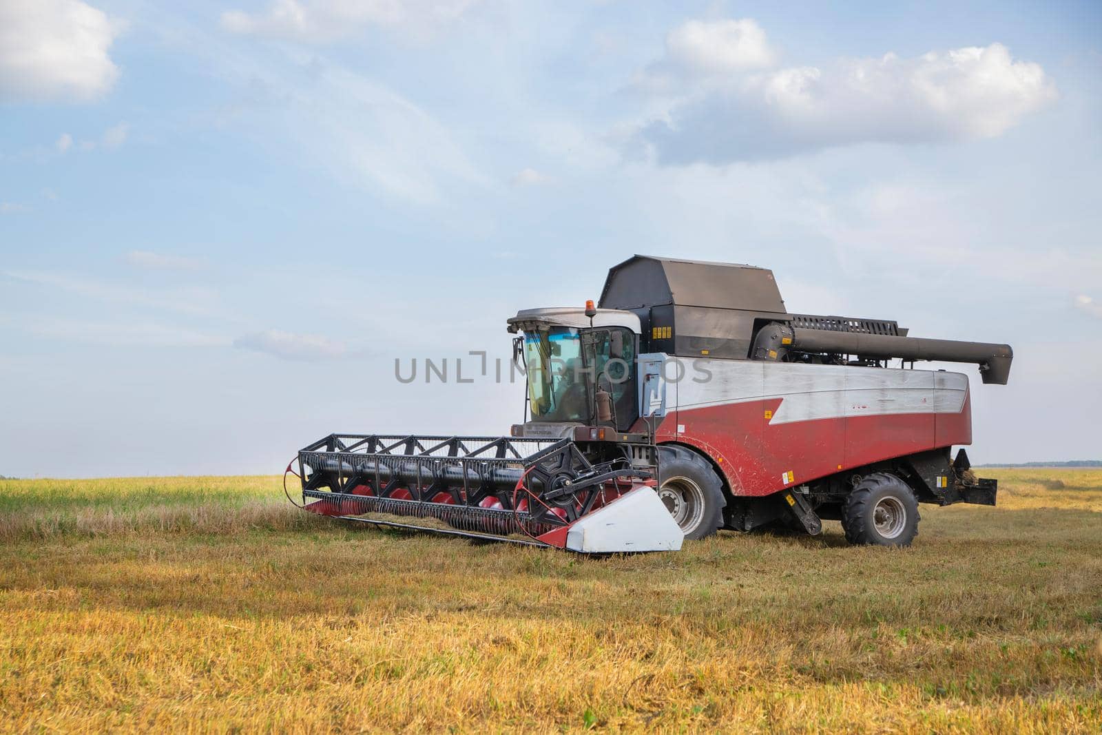 old combine harvester harvests from the field.