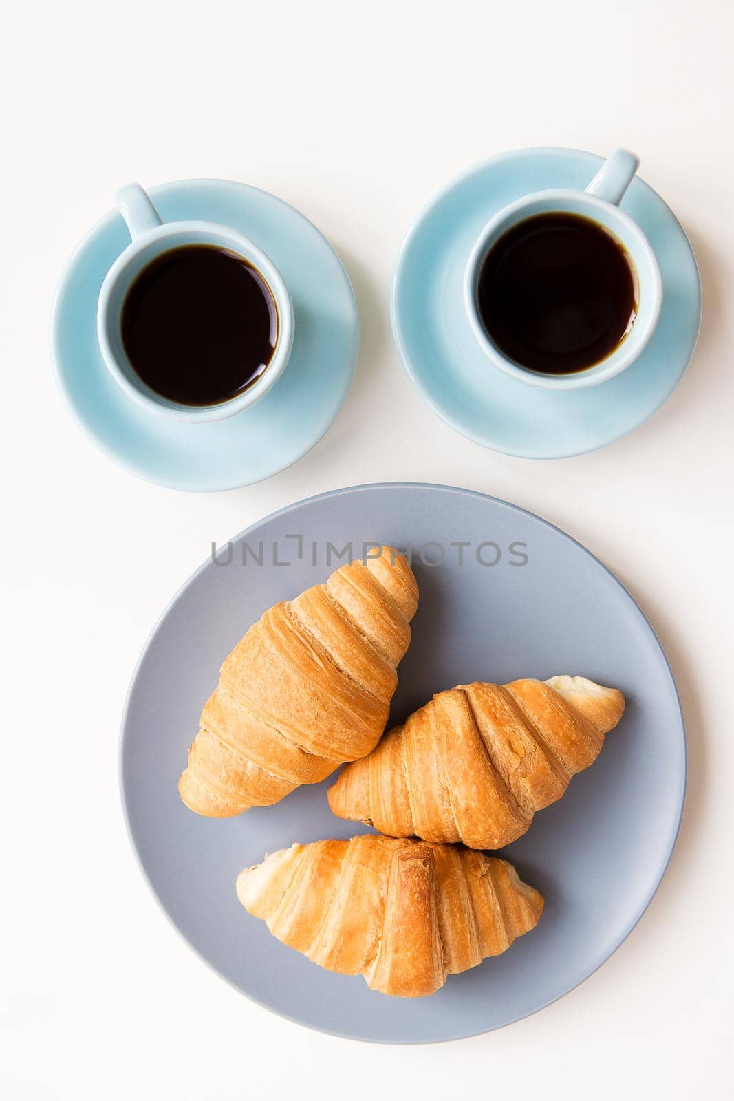 cup of coffee with croissant on white background.