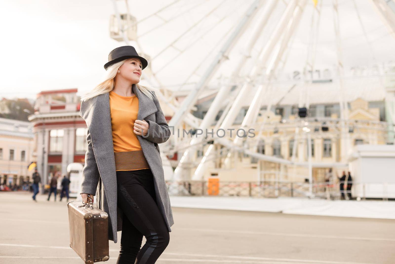 Stylish woman posing near ferris wheel