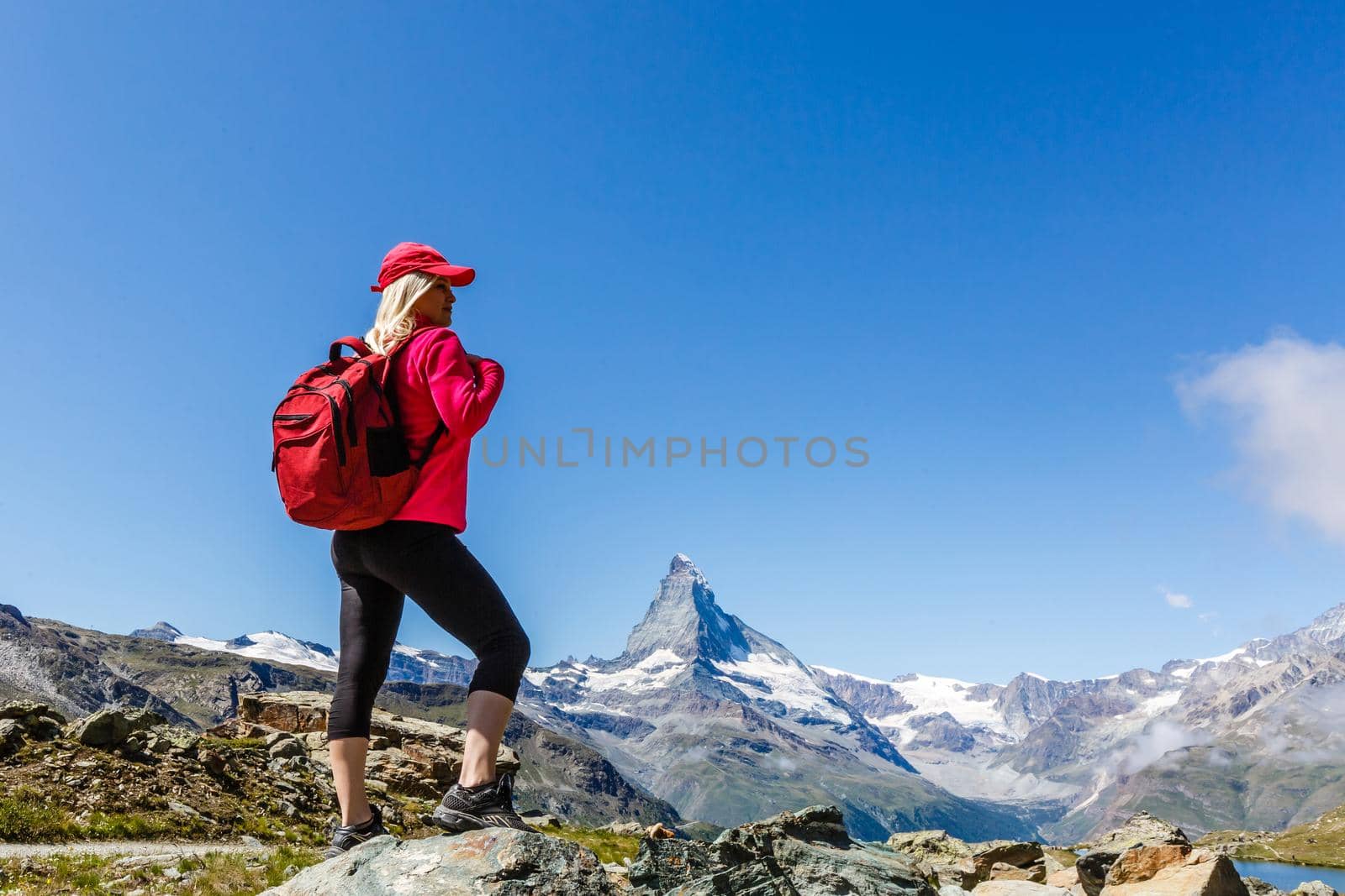Hiking - hiker woman on trek with backpack living healthy active lifestyle. Hiker girl walking on hike in mountain nature landscape in Swiss alps, Switzerland