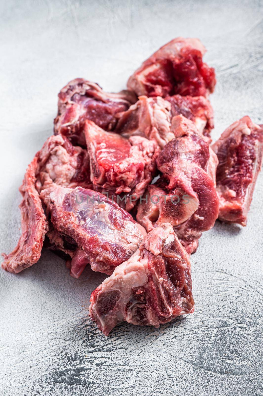 Raw lamb meat stew cuts with bone. White background. Top view.