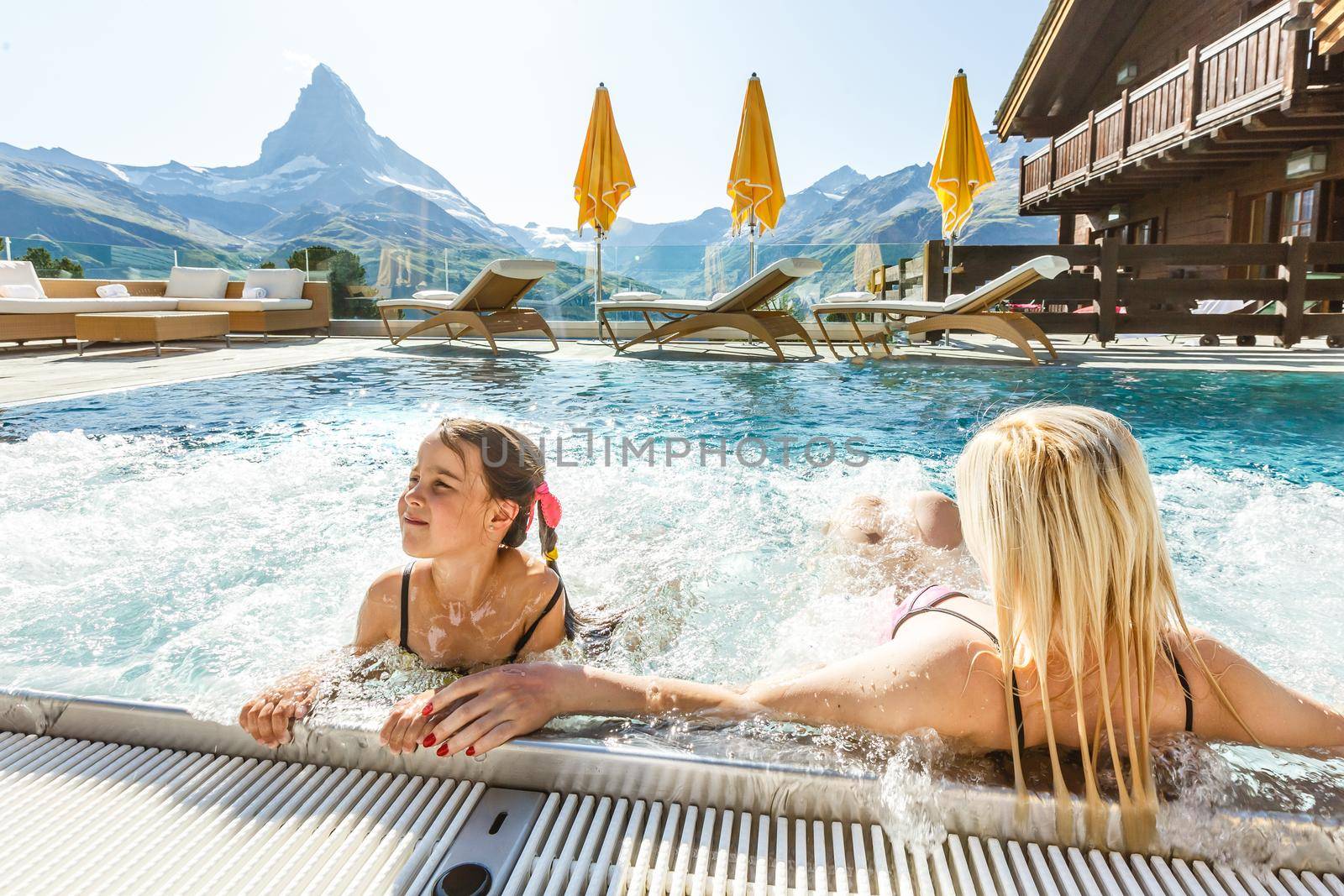 Mother And Child Girl Swimming In Pool In Mountains