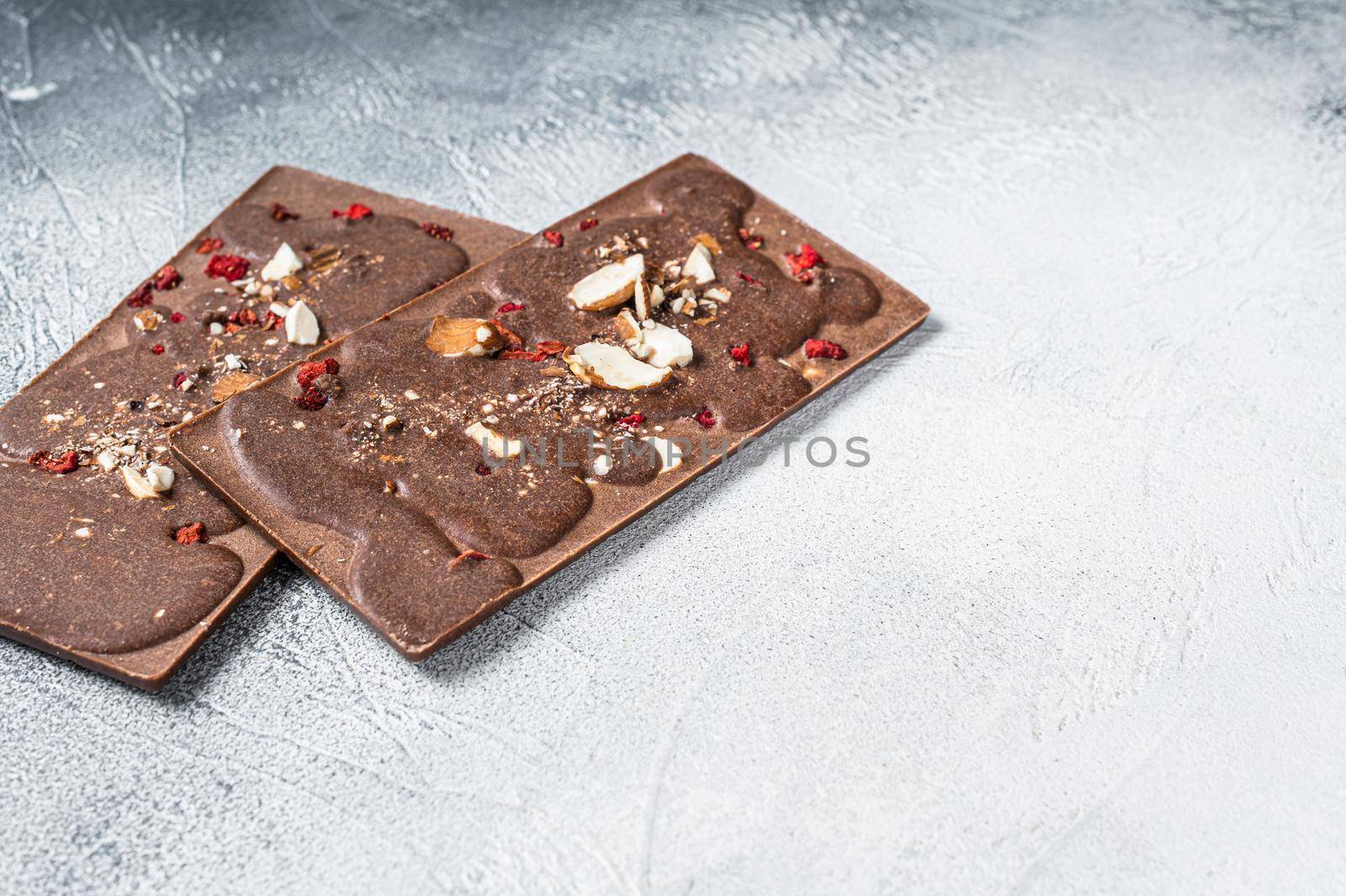 Craft homemade chocolate bars on kitchen table. White background. Top view. Copy space.