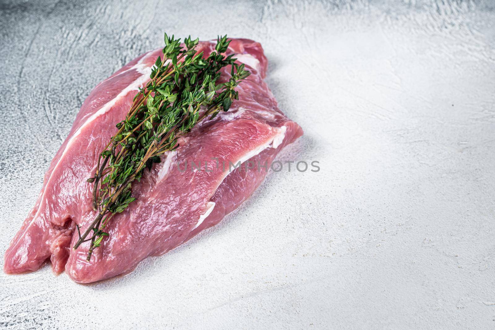 Raw pork shoulder meat on a butcher table. White background. Top view. Copy space.