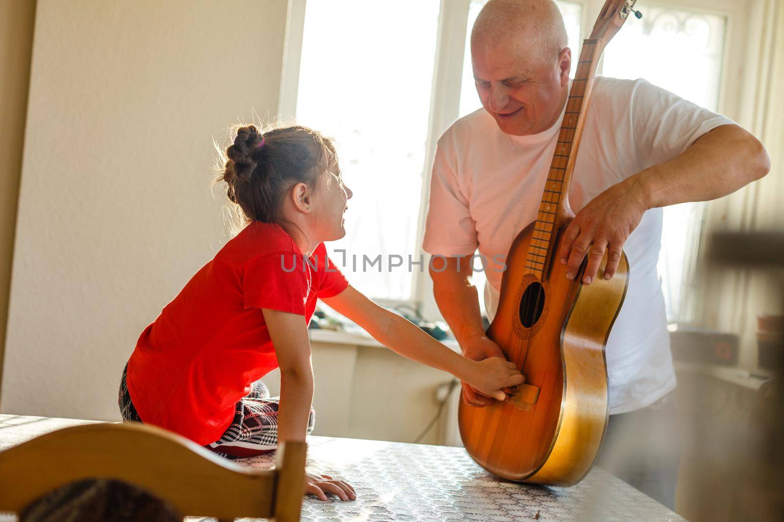 closeup man's hand changing strings on his old acoustic guitar. by Andelov13