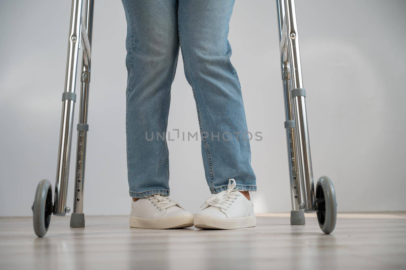 Close-up of female legs with walkers. The girl walks with the help of special equipment