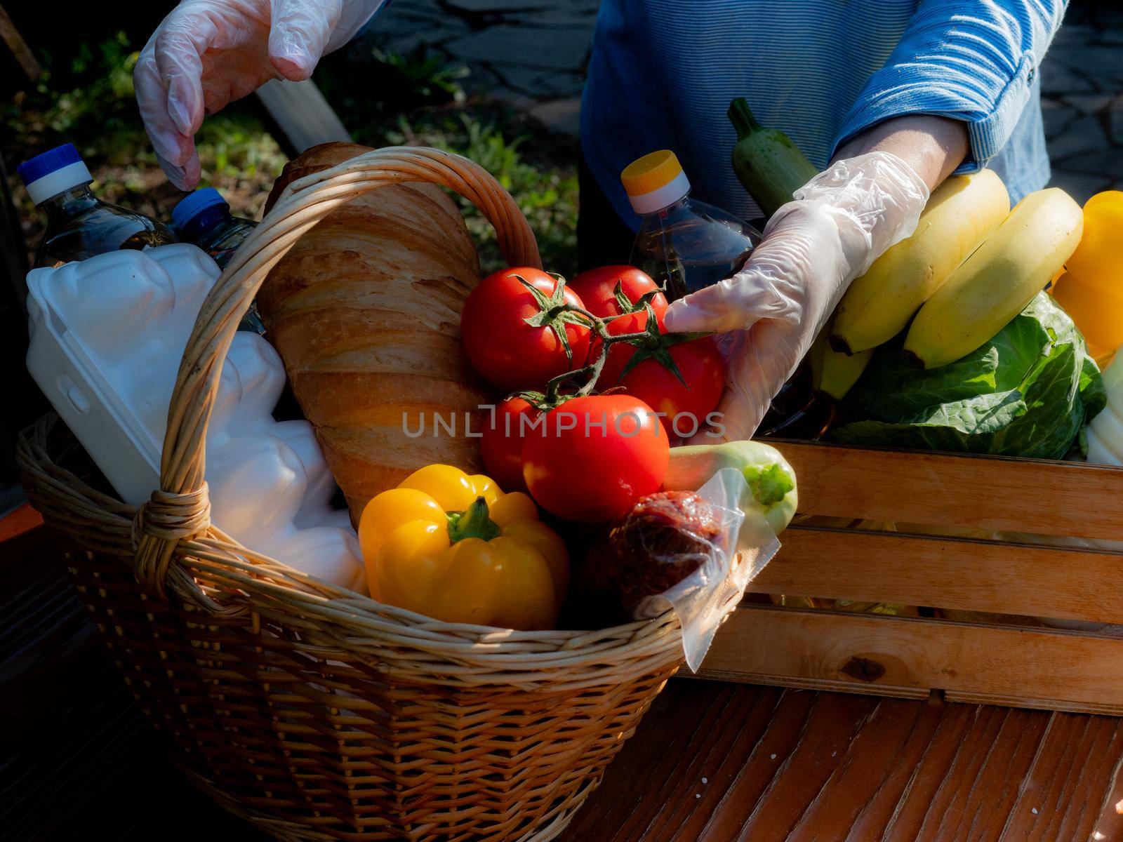 Female volunteer puts in a basket of food for the homeless, the close-up. by Utlanov