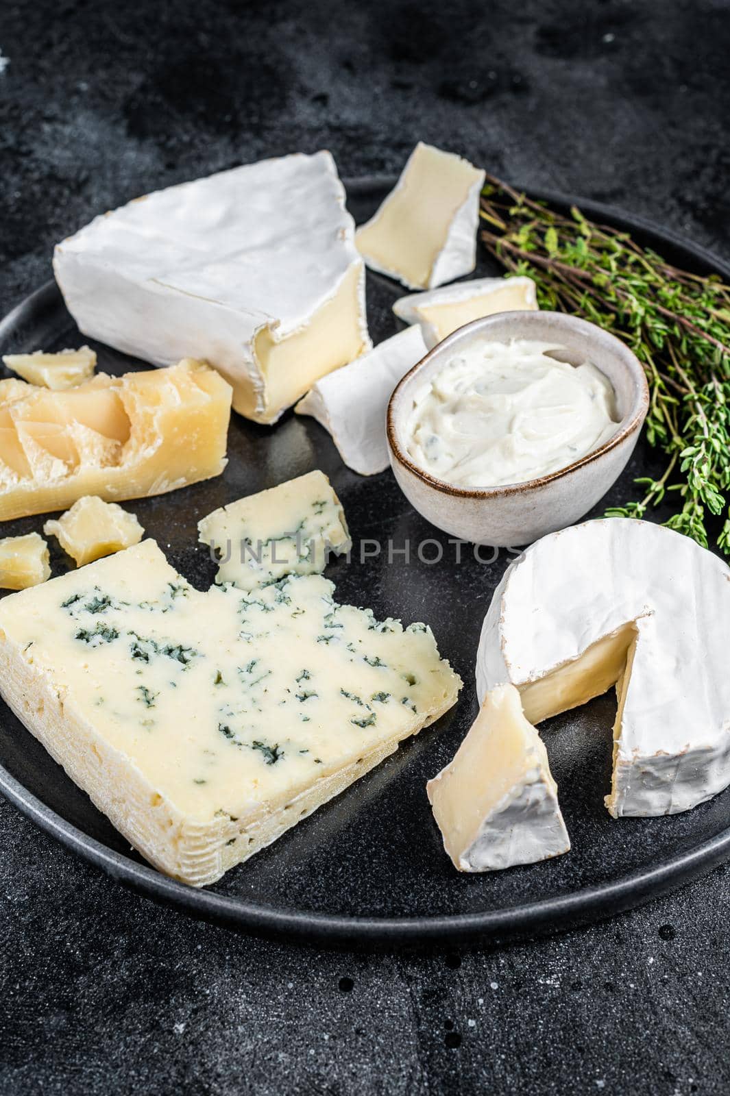 French Cheese plate. Camembert, Brie, Gorgonzola and blue cream cheese. Black background. Top view by Composter