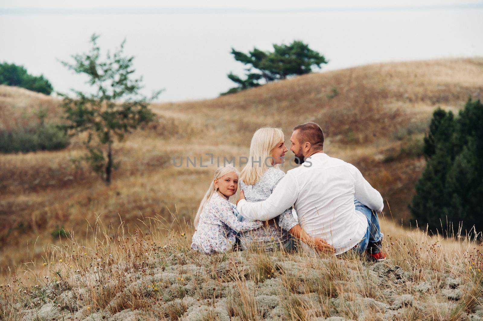 A happy family of three on the sand dunes of the Baltic sea near the city of Nida.Lithuania.