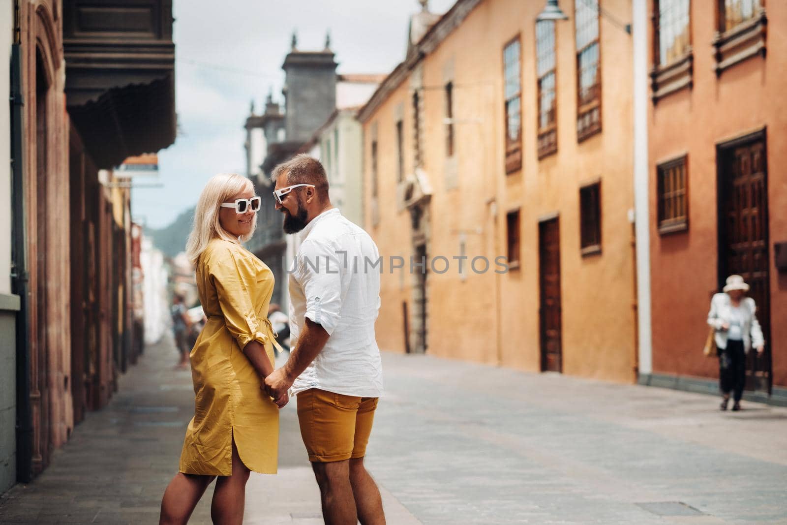 a modern married couple of lovers strolling in the old town of the island of Tenerife, a couple of lovers in the city of LA Laguna by Lobachad