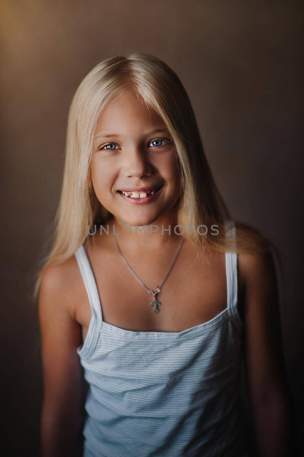 Portrait of a beautiful blonde girl in her apartment. With long loose hair smiling.